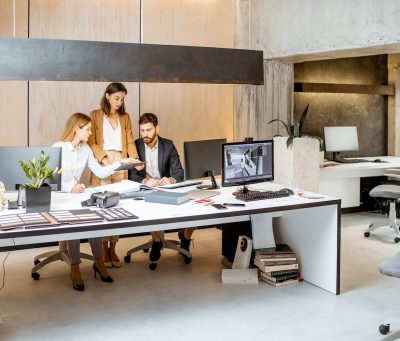 Small group of creative office employees working together on some architectural project in the modern office. Concept of an architectural business and creative work
